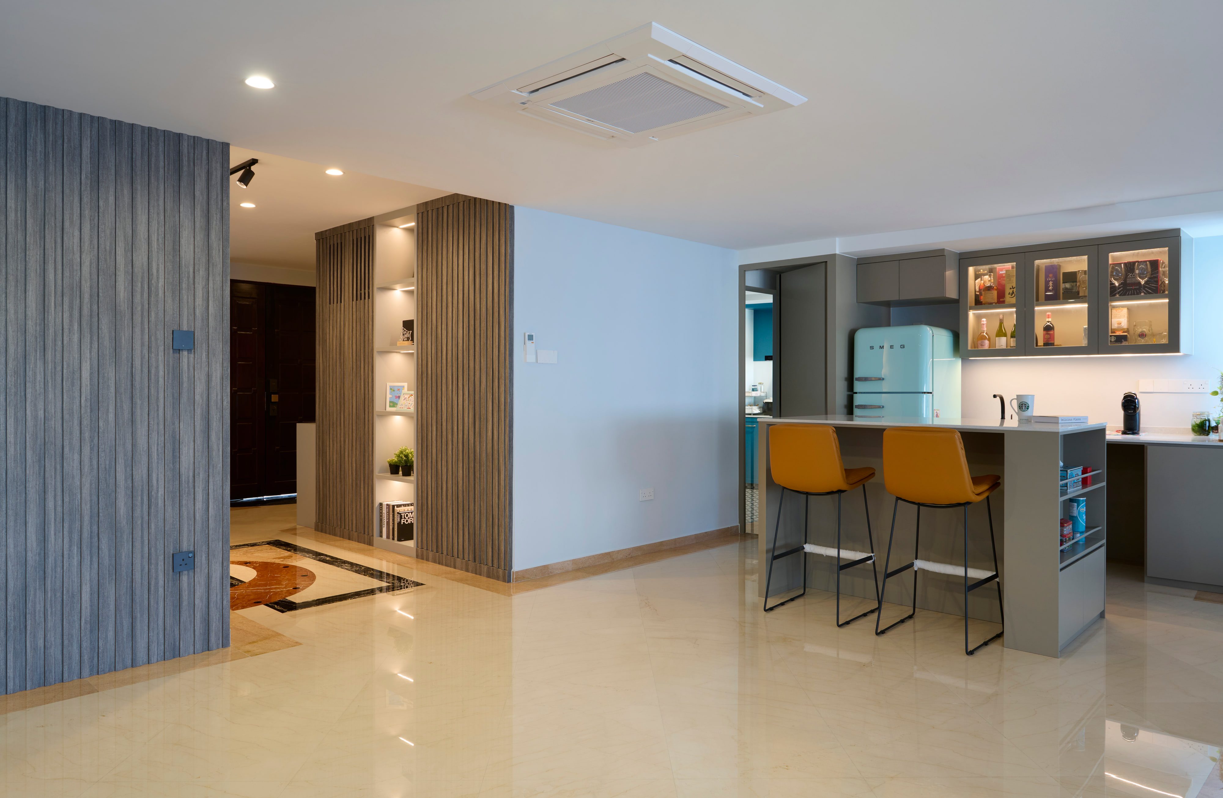 The entrance looking through to the kitchen, a blue-grey slatted wall at left, mustard stools at the island and a mint-green retro refrigerator.